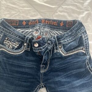 Rock revival blue jeans, style ENA/skinny size 25/30 button back pockets # 02